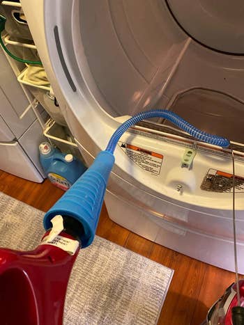 A reviewer's attachment hooked up to a vacuum and fed into the dryer vent 