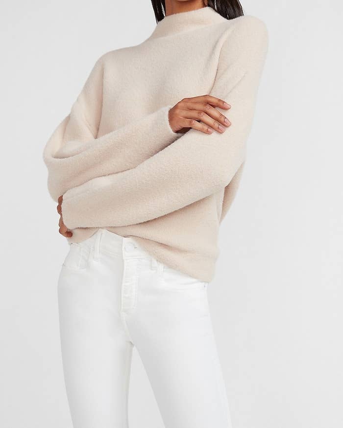 A model in the cream sweater