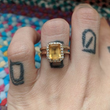 A reviewer photo of a ring with a cloudy yellow gemstone 