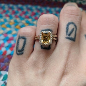 A reviewer photo of the same ring with the yellow stone shining 