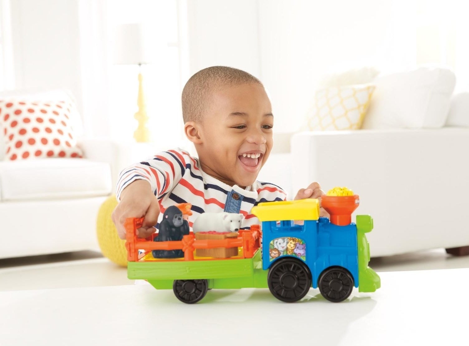child playing with a toy train that has two animals in it