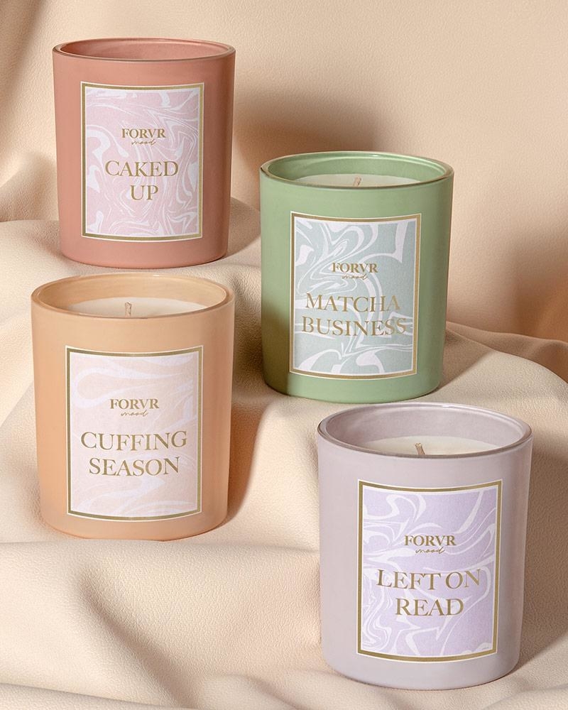 a pink, green, orange, and purple candle with the names &quot;caked up, matcha business, cuffing season, and left on red