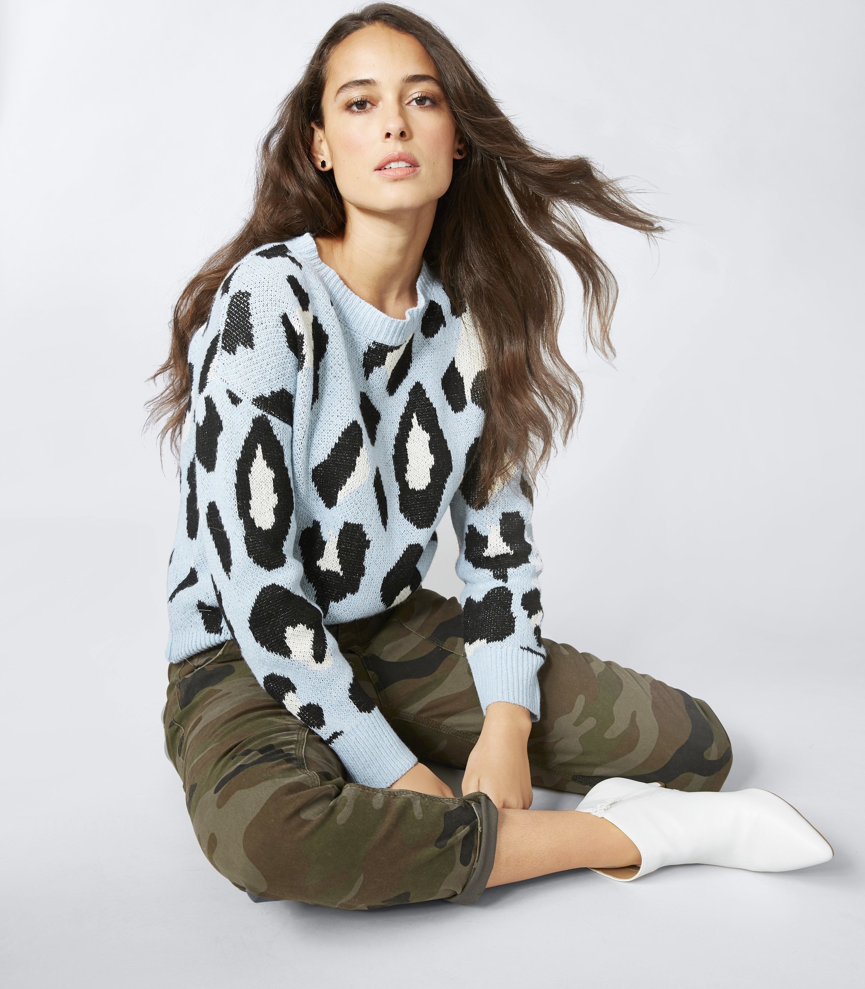 person wearing a blue leopard sweater and camo pants