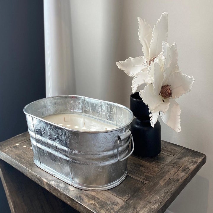 large oval tin tub (about a foot long)  with a candle inside that has multiple wicks