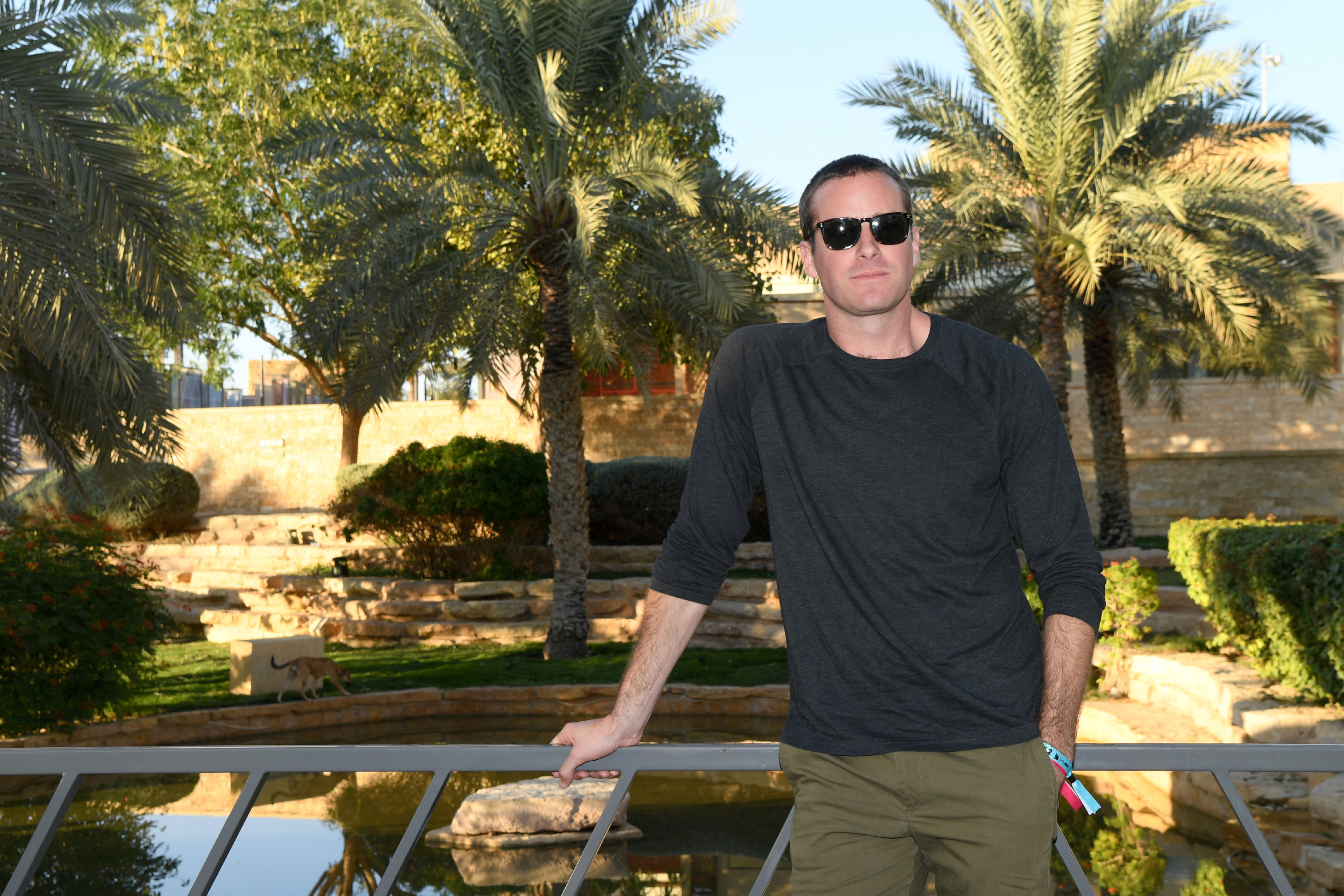 Armie Hammer wears sunglasses, a gray long-sleeve shirt, and dark green pants at the MDL Beast Festival Lunch in Saudi Arabia