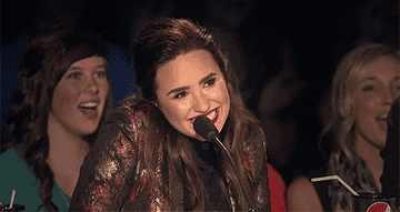 Demi Lovato with a microphone looking shy