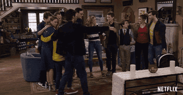 The family from Fuller House embraces in a group hug