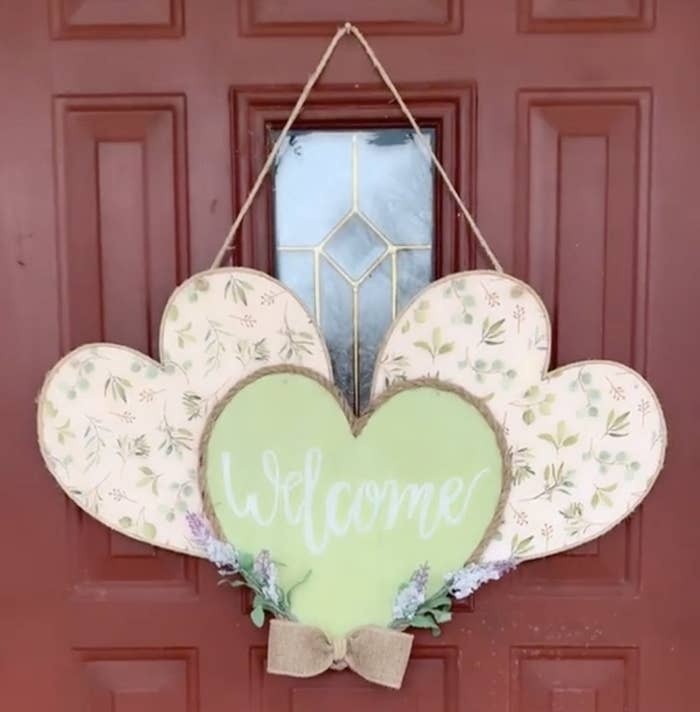 A door hanger with three hearts in a row filled with a pink floral pattern