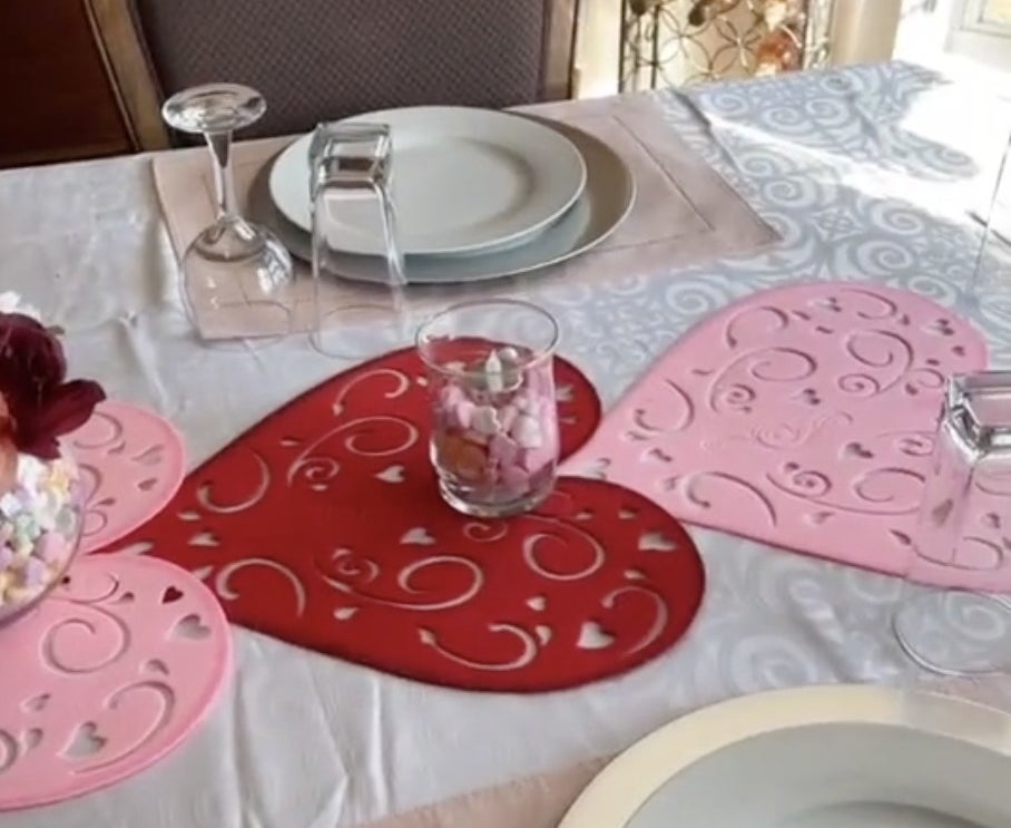 A table setting with three large pink hearts running down the center