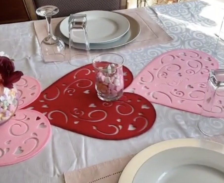 A table setting with three large pink hearts running down the center