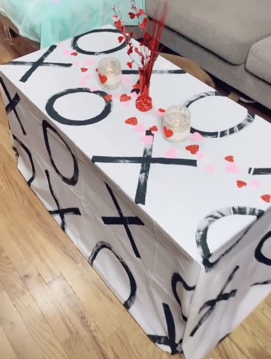 A white table cloth that has XO painted on it 