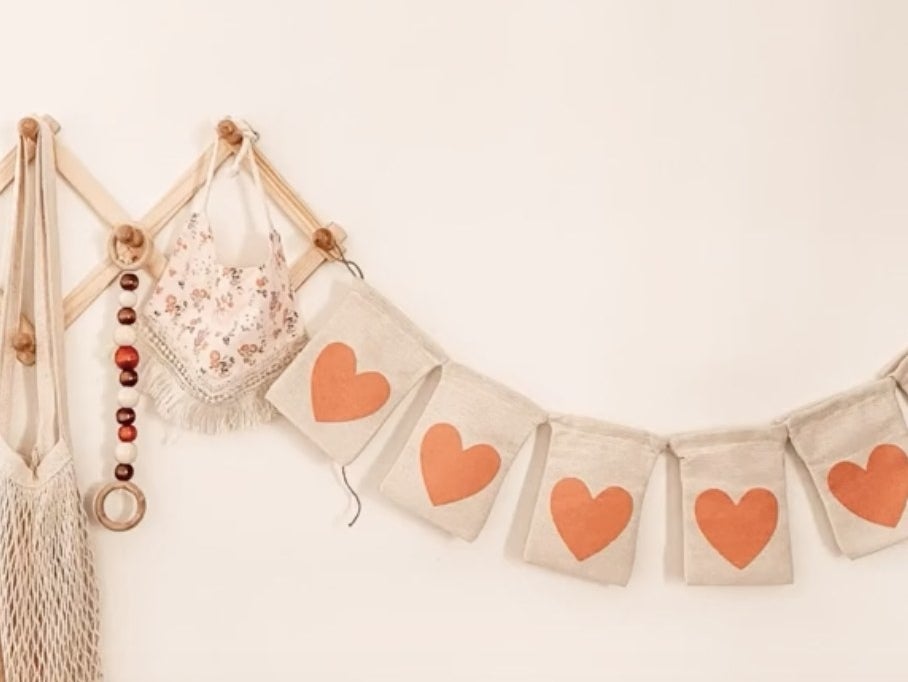 A banner made of pieces of burlap with red hearts on it