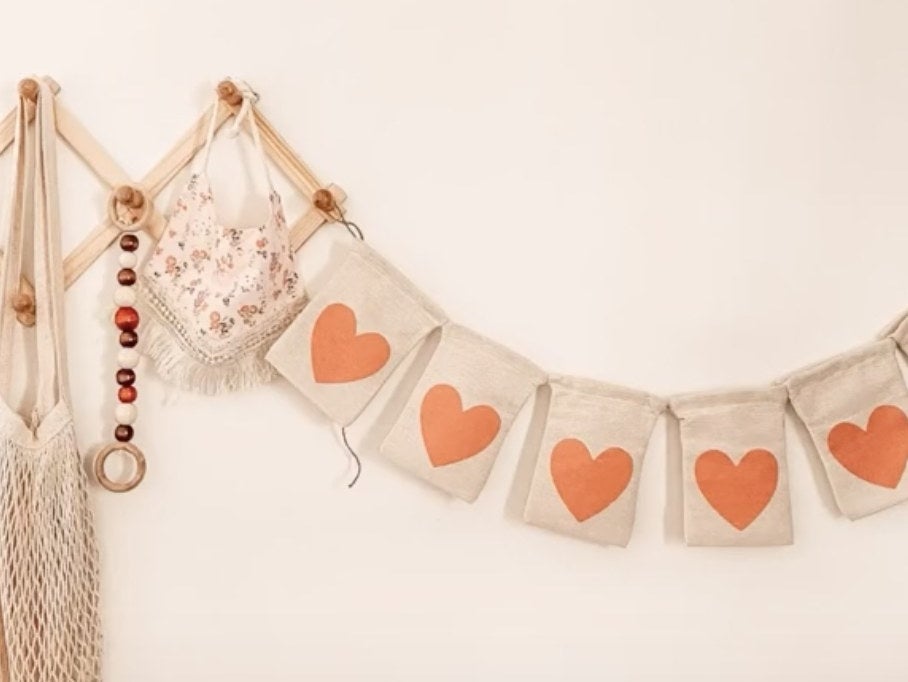 A banner made of pieces of burlap with red hearts on it