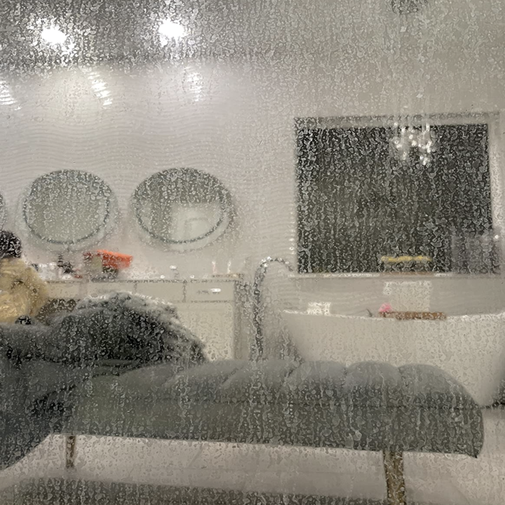 a reviewer's glass shower door looking fogged up from hard water stains