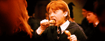 Ron Weasley from Harry Potter eating chicken wings.