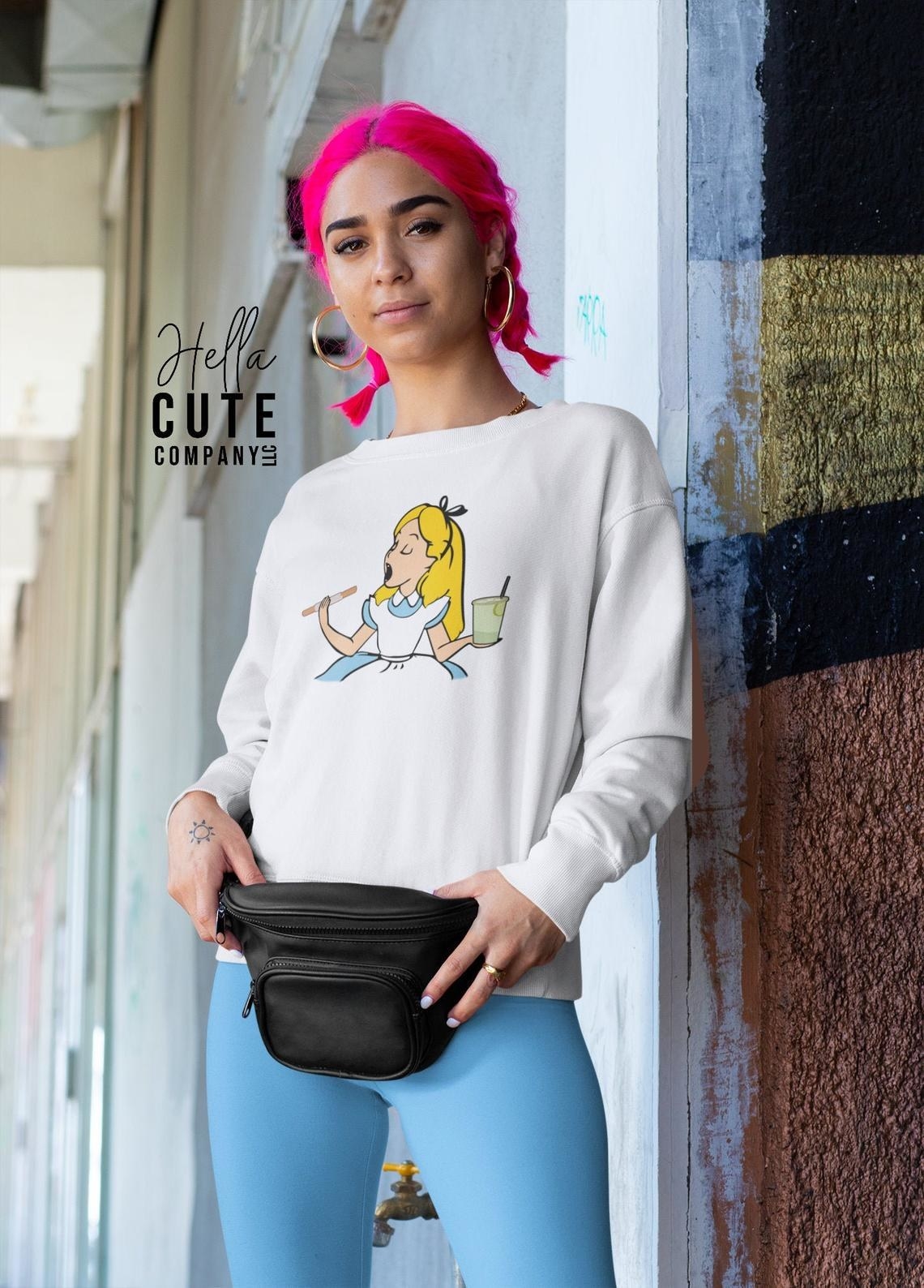 model wearing a sweatshirt with Alice from Alice in Wonderland eating on it