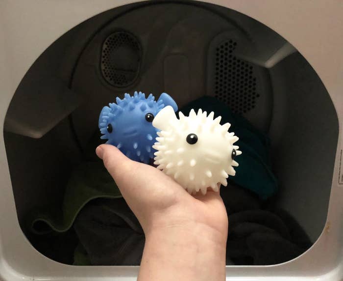 reviewer image of a customer holding the two kikkerland puffer fish drying buddies in front of their open dryer