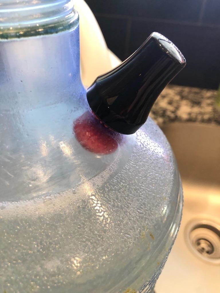 reviewer image of the spot cleaner being used to clean a glass jug