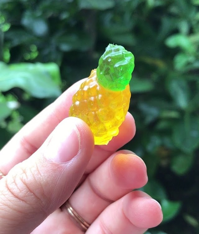 Hand holding pineapple-shaped gummy candy
