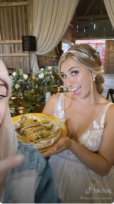 A bride shows off tacos from her wedding food truck