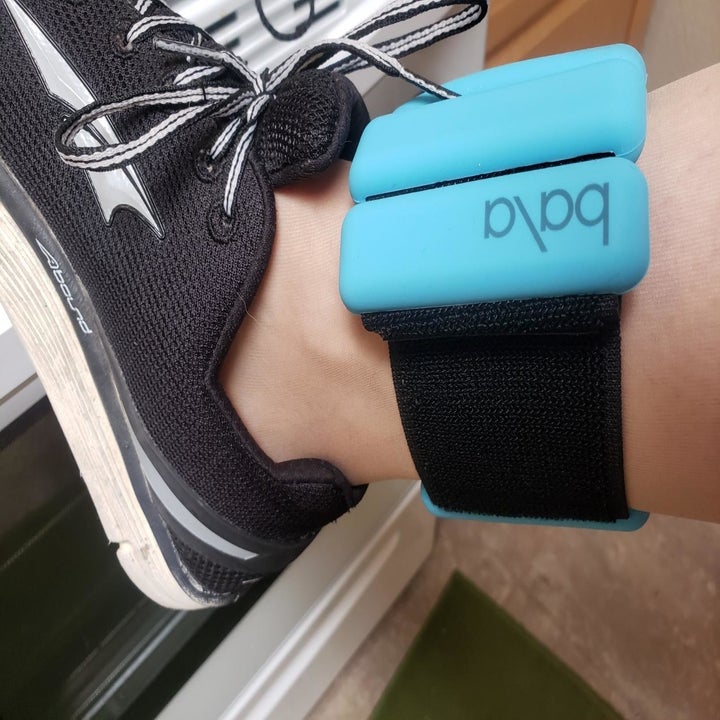 A reviewer wearing the blue weight on their ankle