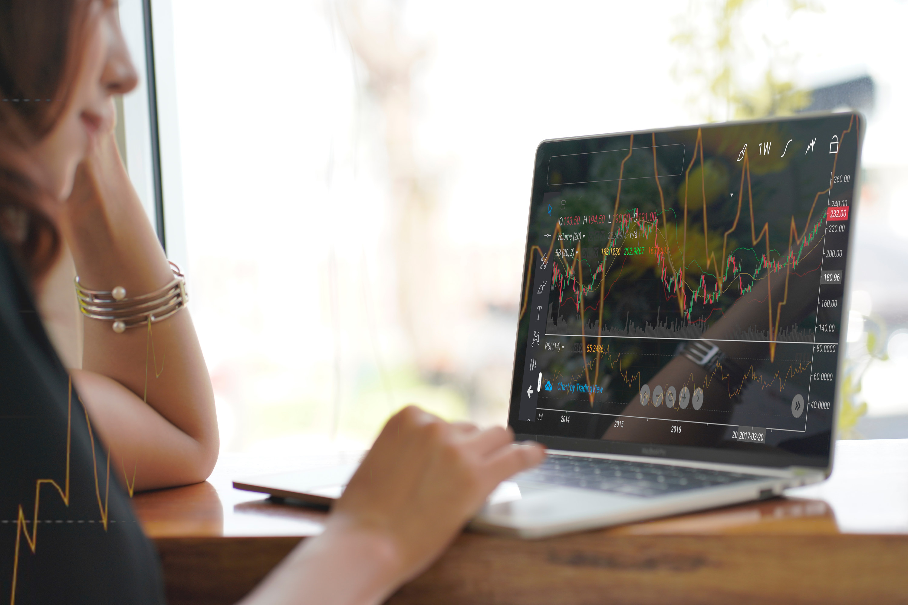 Woman looking at stock charts on a laptop