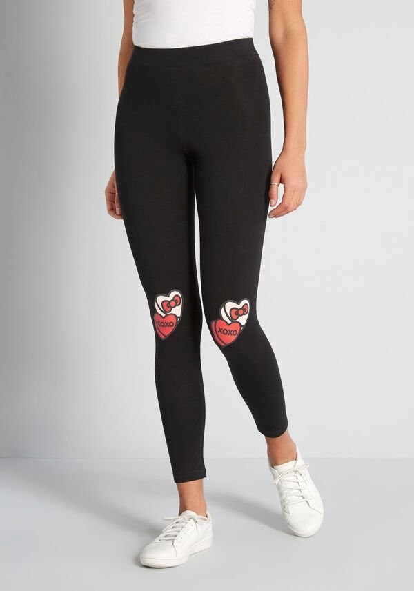 The black leggings with patches shaped like two candy hearts (one reading XOXO and one with a Hello Kitty bow) on the knees