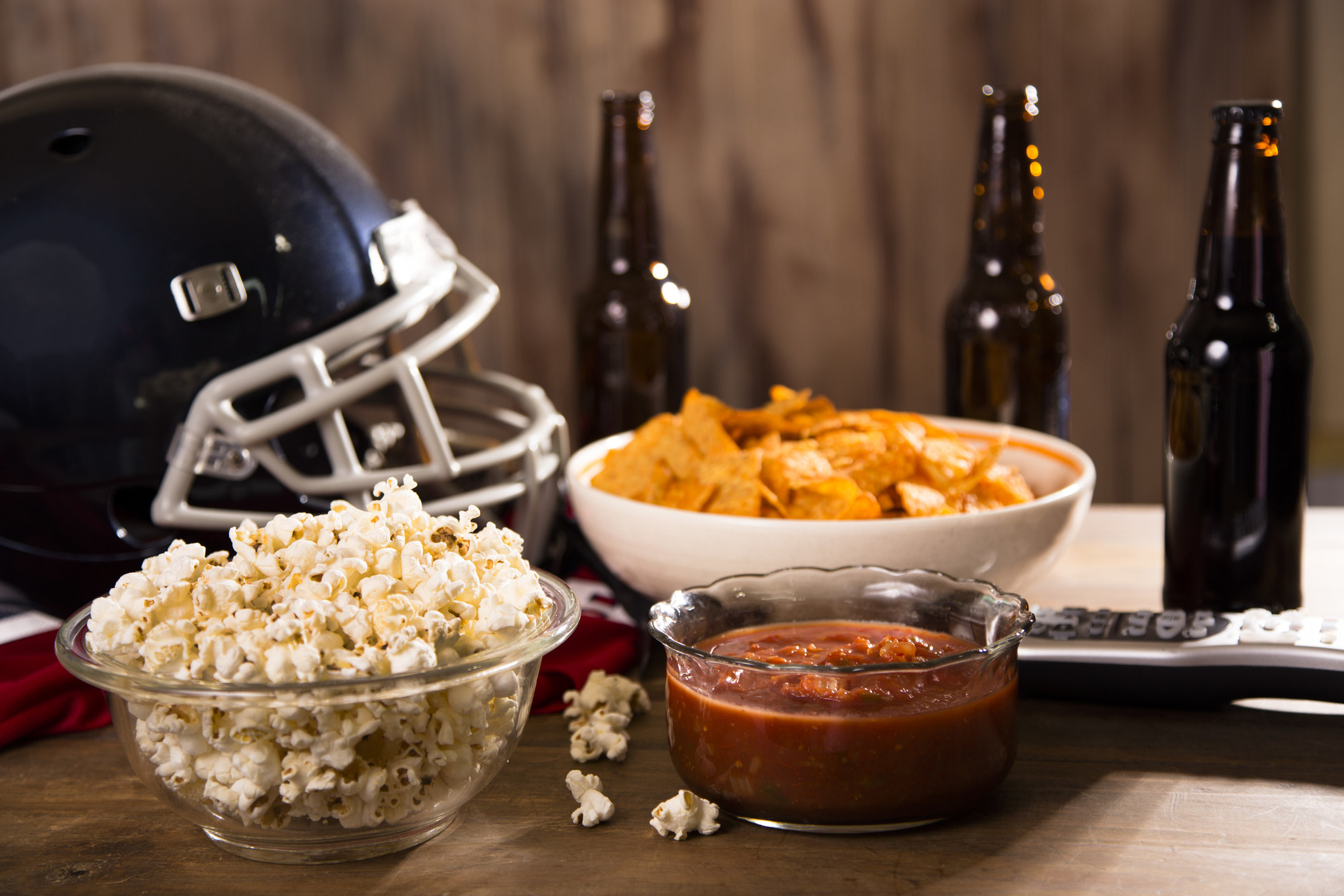 A coffee table filled with snacks and beer for a football-watching party