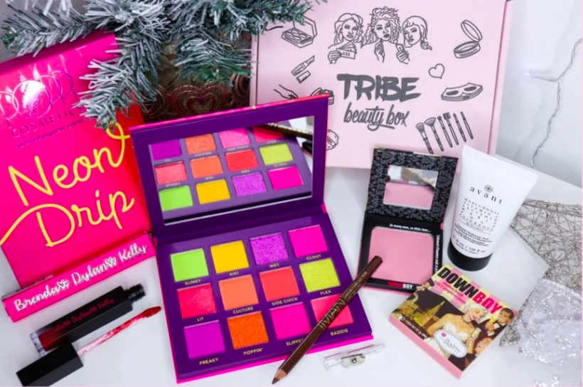 a Neon Drip eye palette, liquid lip, brown eyeliner pencil, and blush next to the beauty box