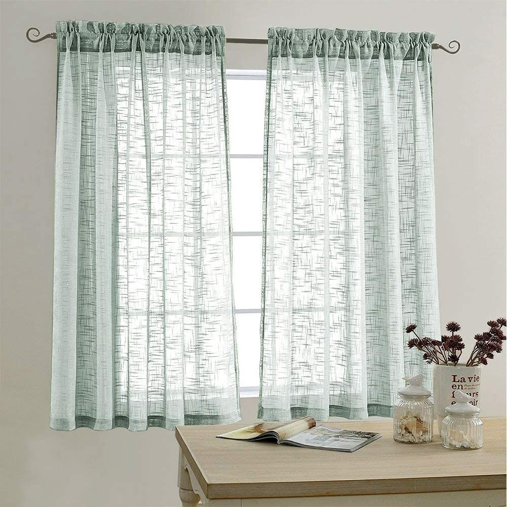 the sheer curtains in blue hanging in front of a window
