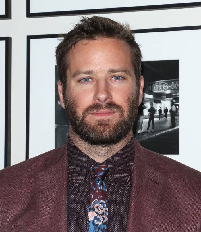 Armie Hammer wears a suit, checkered button-down, and patterned floral tie at the New York screening afterparty for Hotel Mumbai 