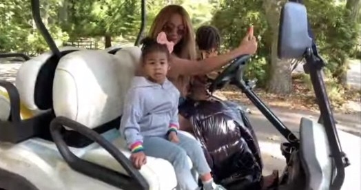 Rumi smiles while riding with her mom in a golf cart