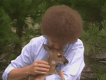 Bob Ross petting a baby deer and smiling 
