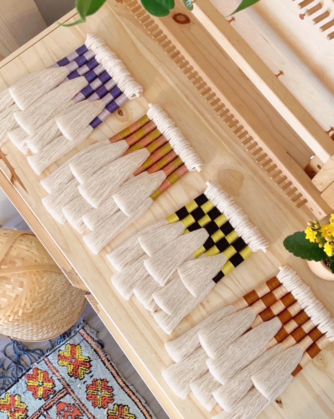 Four tassel wall hangings with checkered fiber pattern
