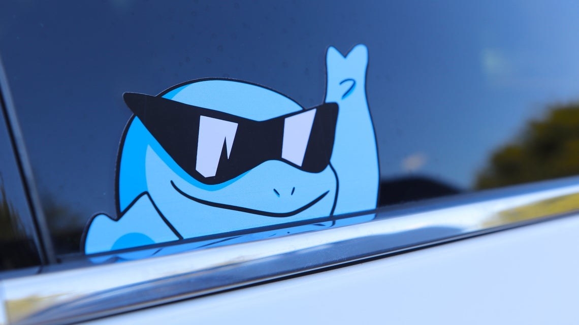 car window with sticker of squirtle in sunglasses waving