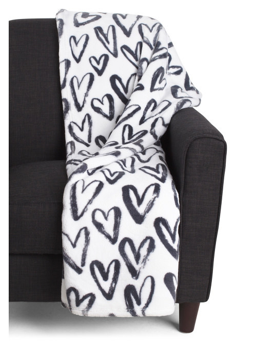 a white throw blanket with black hearts on it