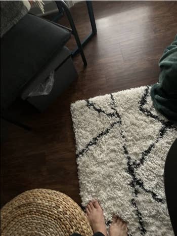 a reviewer photo of a rug on the floor to show that the rug grippers are undetectable 