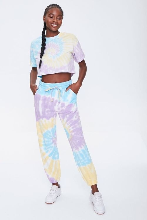 Model wearing the yellow, lavender, and blue sweatpants with matching tee