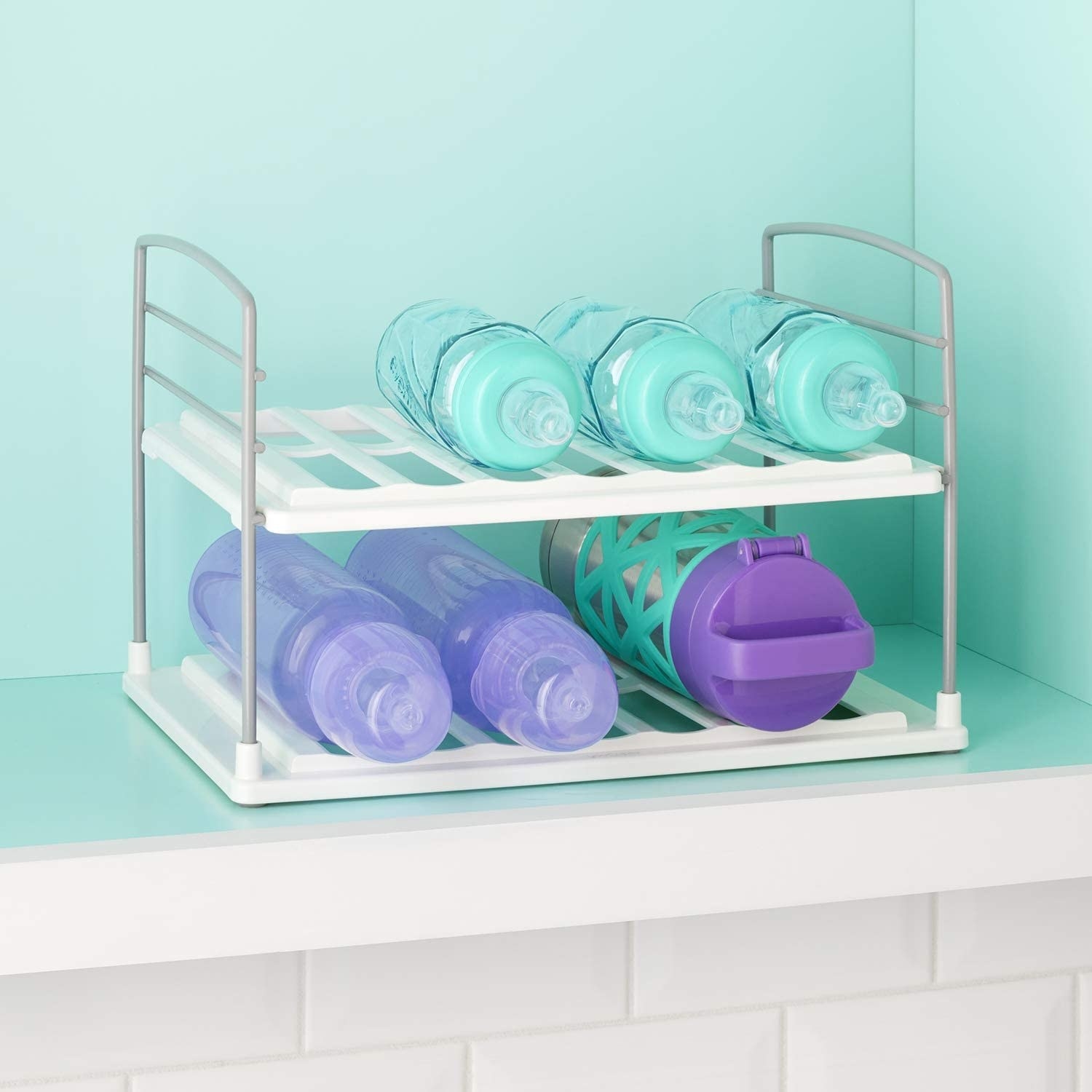 A grooved water bottle rack inside a kitchen cabinet