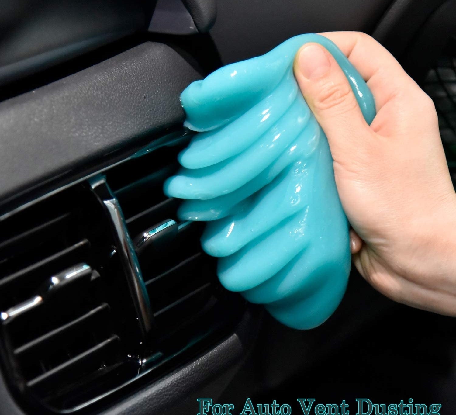A person using the cleaning gel on a vent inside of a car