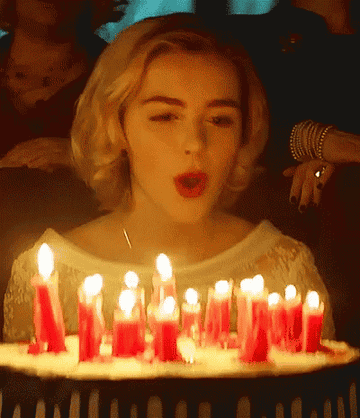 Character blowing out candles on a birthday cake