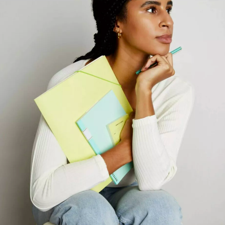Person holding paper office supplies
