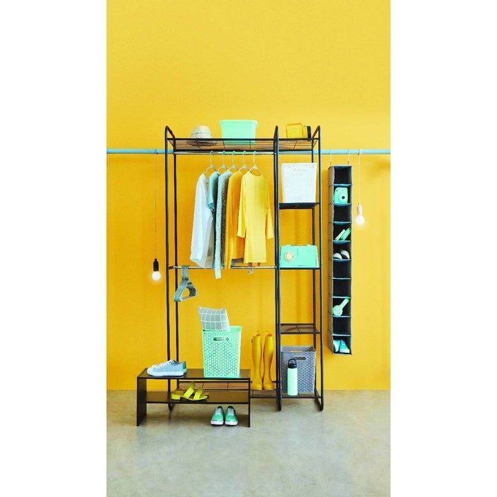 black freestanding closet in front of a yellow wall