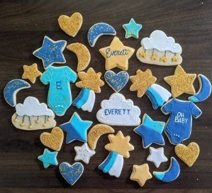A community member showing sugar cookies decorated to be a baby boy theme