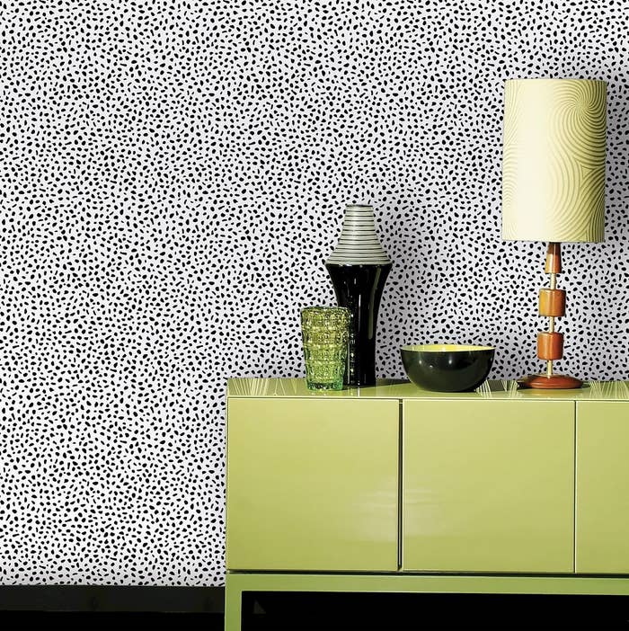 dotted wallpaper on a wall with green furniture in front of it