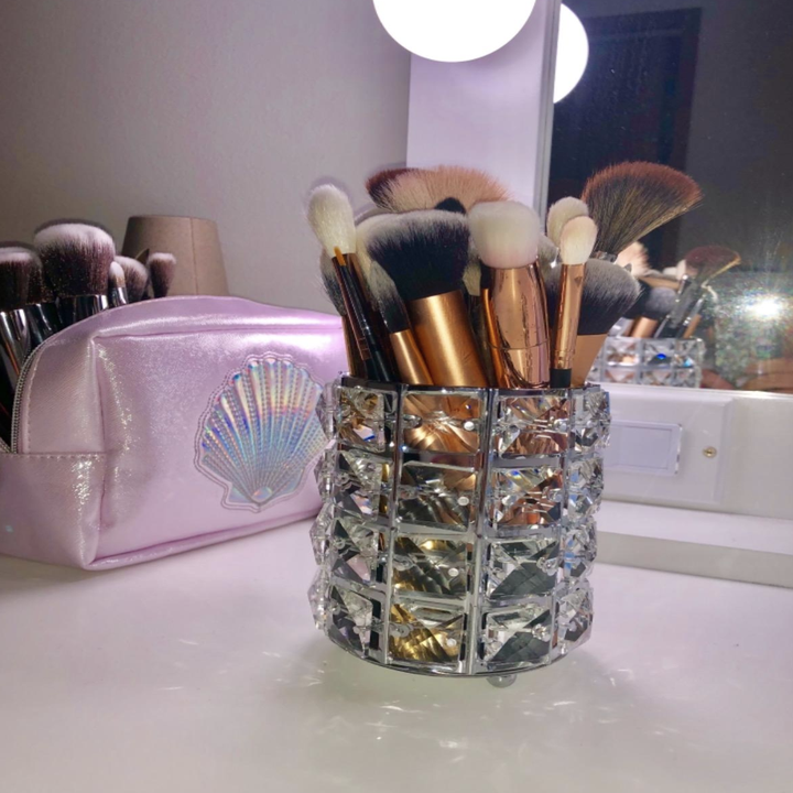 A shiny faux crystal cup-sized brush holder with brushes in it 