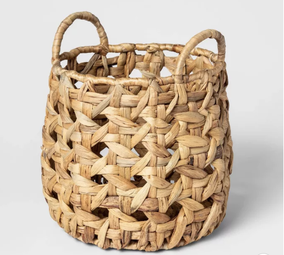 A round woven basket in a beige brown with handles 