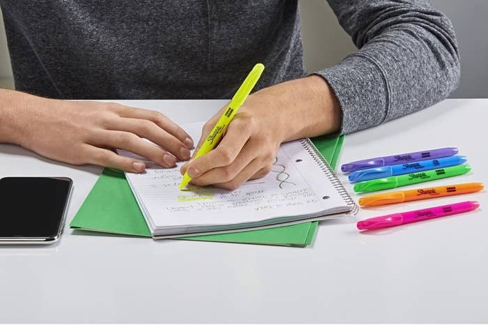 a person using the highlighters to write notes