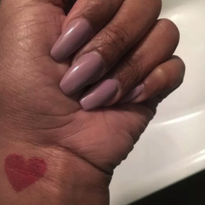 Someone's hand with a red heart tattoo on their wrist