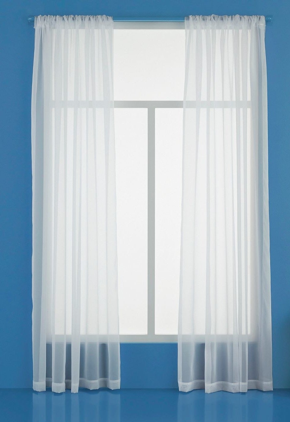 two sheer panel curtains over a window